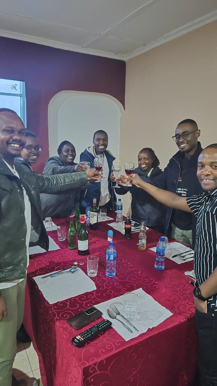 Members of the Mwita & Co. team raising glasses together during a festive gathering.